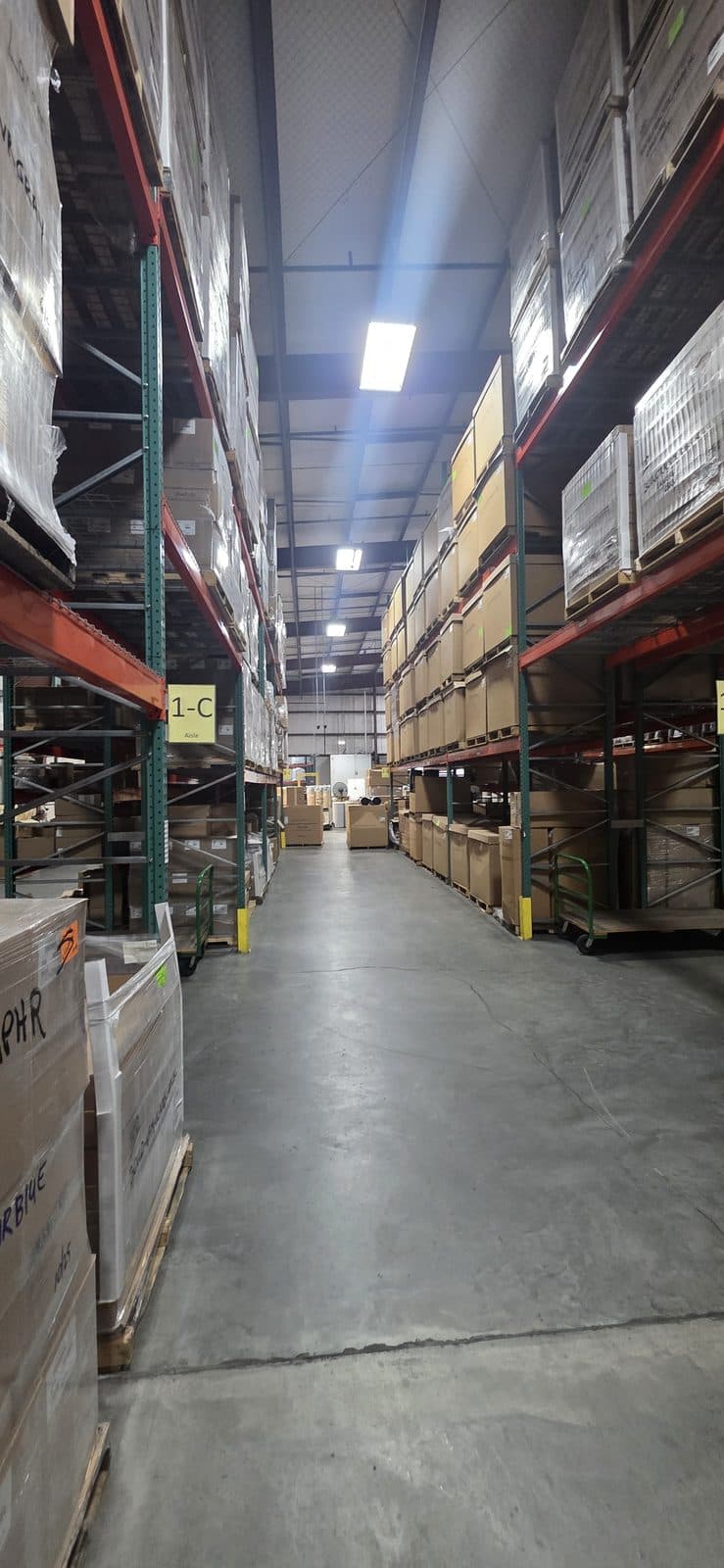 Tall warehouse aisle of palletized finished water treatment systems ready to ship