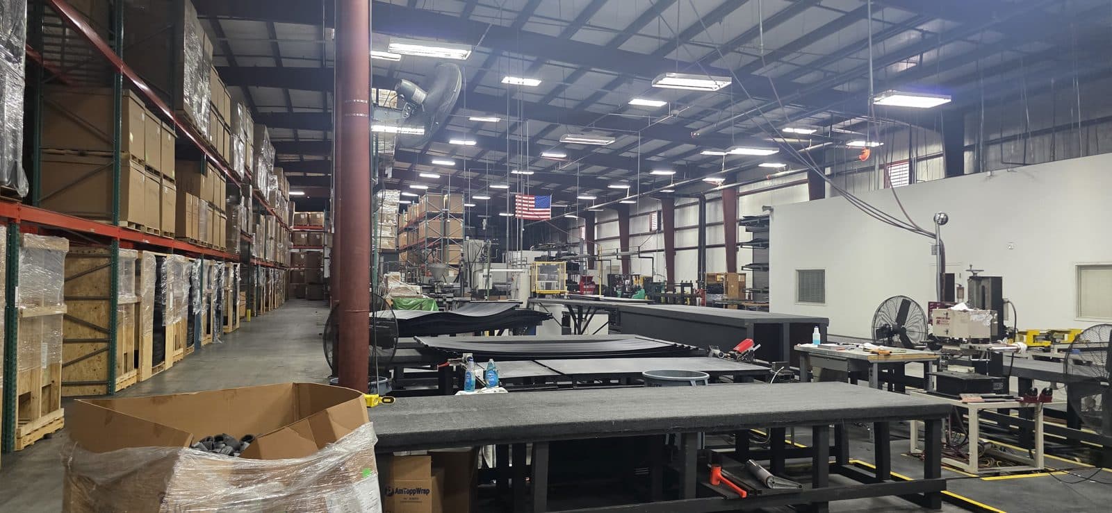 Aquonyx production floor with pallet racking, work tables, and an American flag