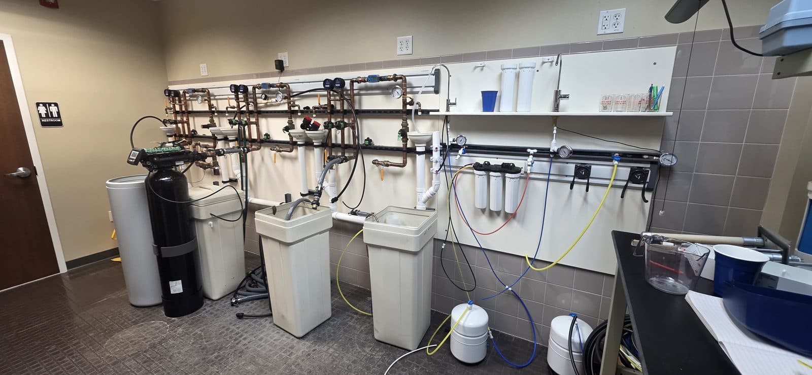 Aquonyx in-house water testing lab with plumbed test rigs, softeners, brine tanks, and reverse osmosis units